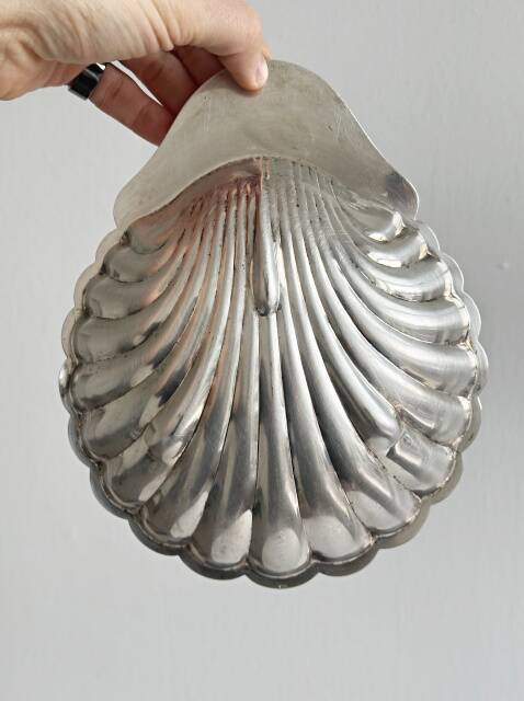 Old metal plate in the shape of a shell.