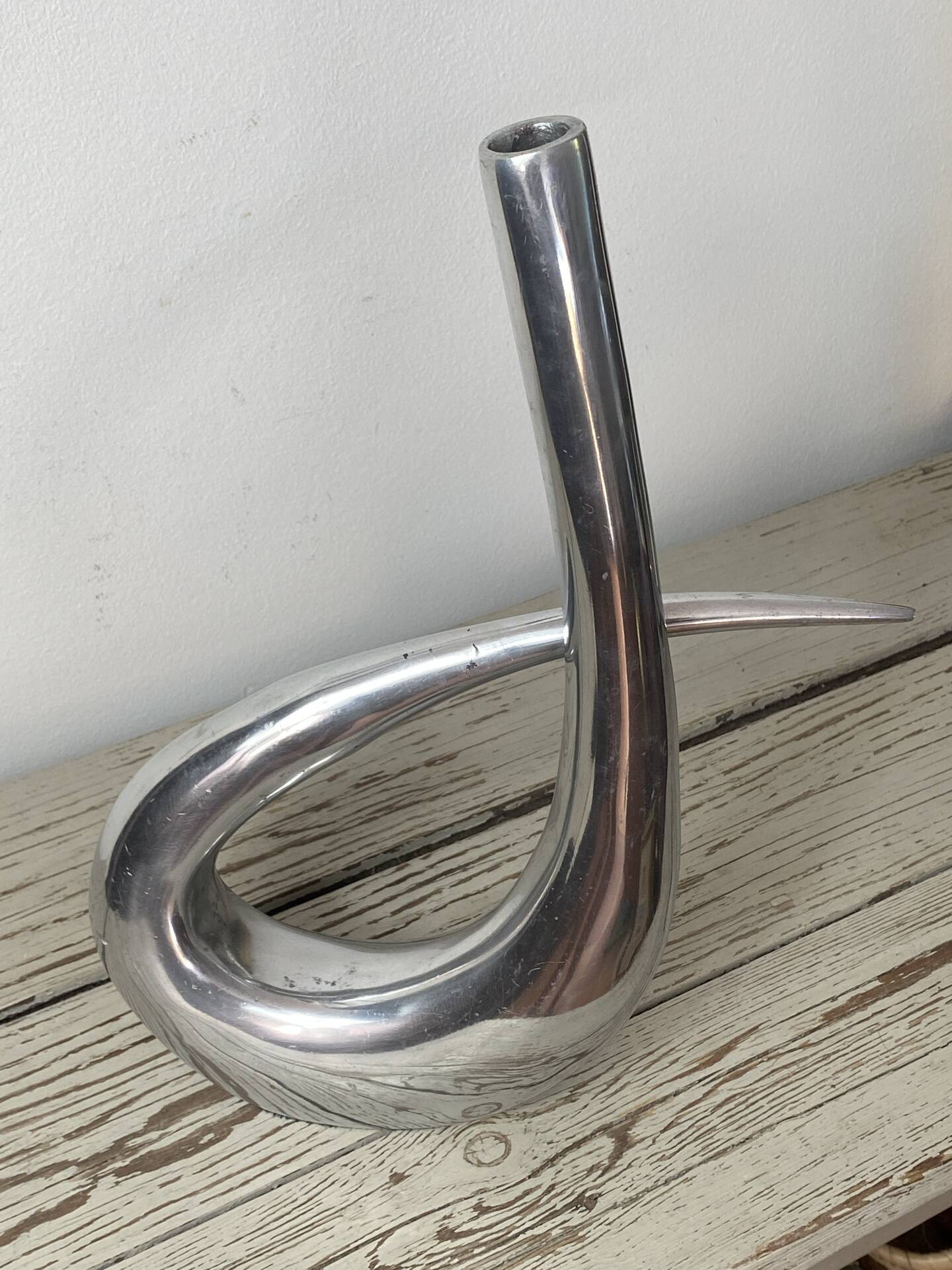 Sculptural vase design in polished aluminium.