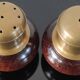 Vintage salt and pepper shaker duo in brass and turned wood.