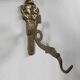 Vintage brass coat hook with marine creature motif and medallion.