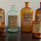 Lot d'anciens flacons de parfumeurs en verre avec étiquettes d'origine