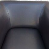 2 club armchairs with a chocolate faux leather seat and backrest and wooden legs.