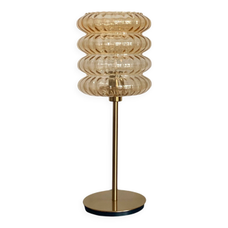 Table lamp with a golden striated globe and a golden base
