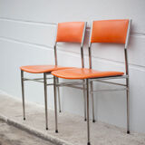 Pair of chrome metal chair and orange skai