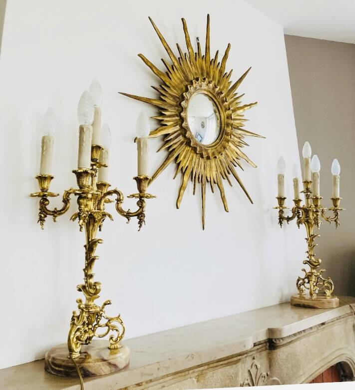 Massive gilded bronze chandeliers from the mid-20th century with marble bases.