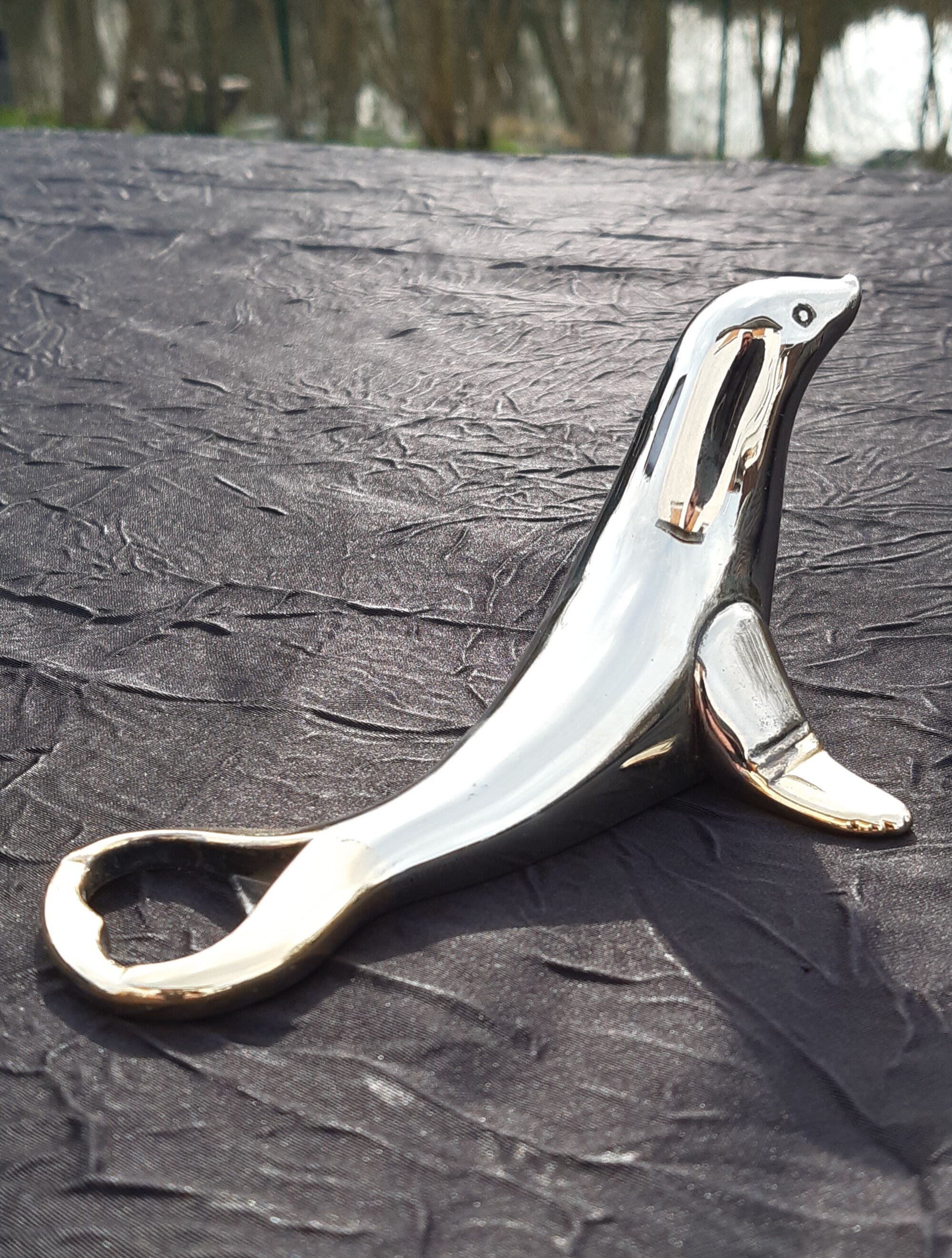 Silver and gold metal sea lion bottle opener