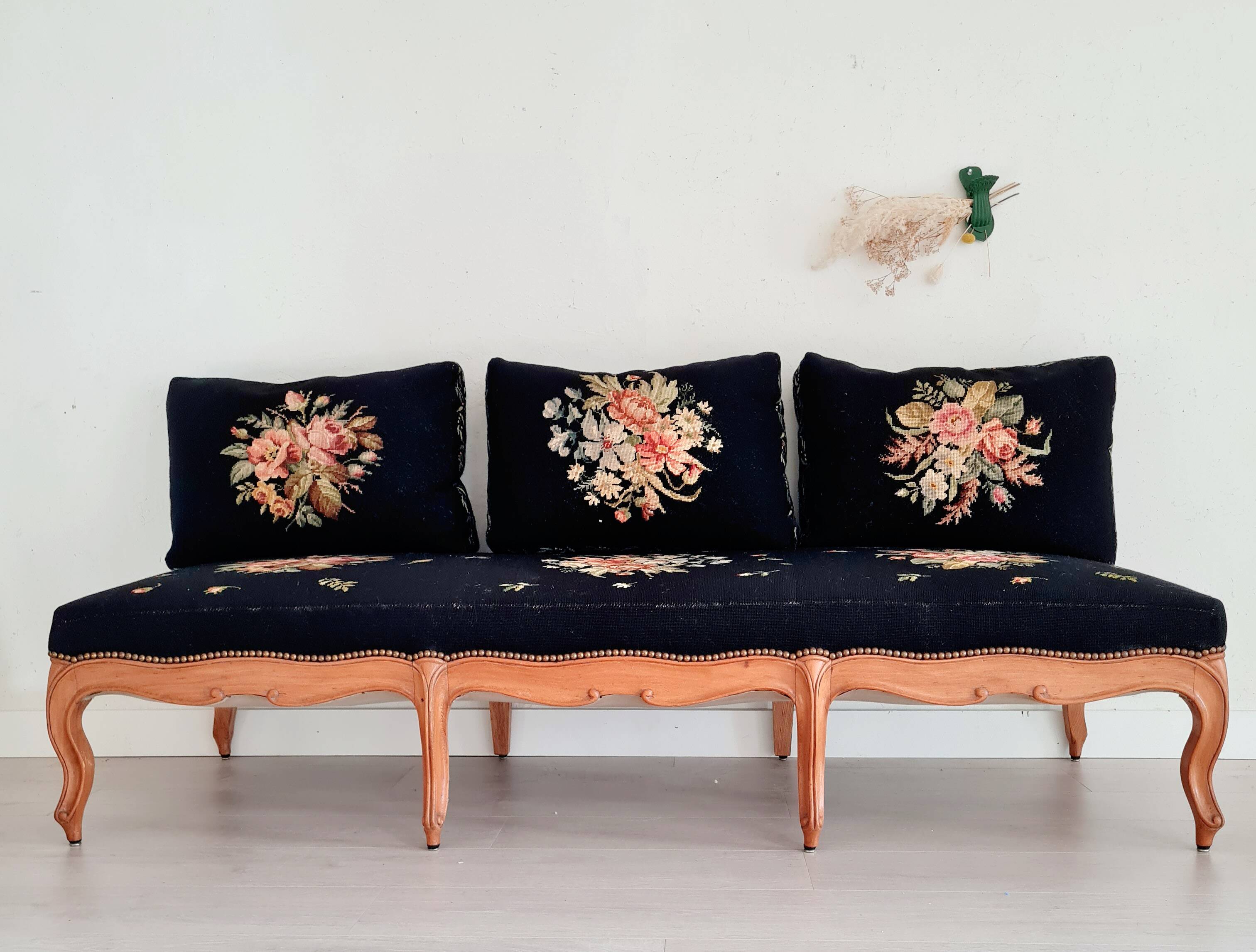 Old bench upholstered in black canvas flowers