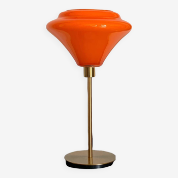 Table lamp with a vintage orange glass globe and a gold base