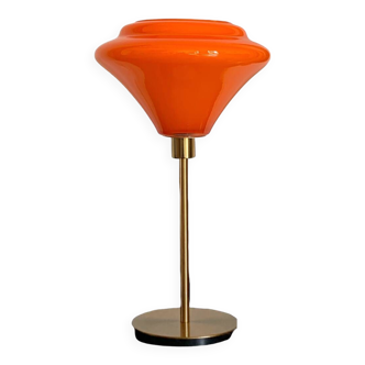 Table lamp with a vintage orange glass globe and a gold base