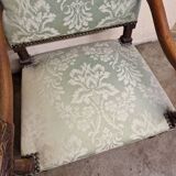 Antique Louis XIV style armchair in moulded wood and damask-style fabric.