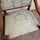 Antique Louis XIV style armchair in moulded wood and damask-style fabric.