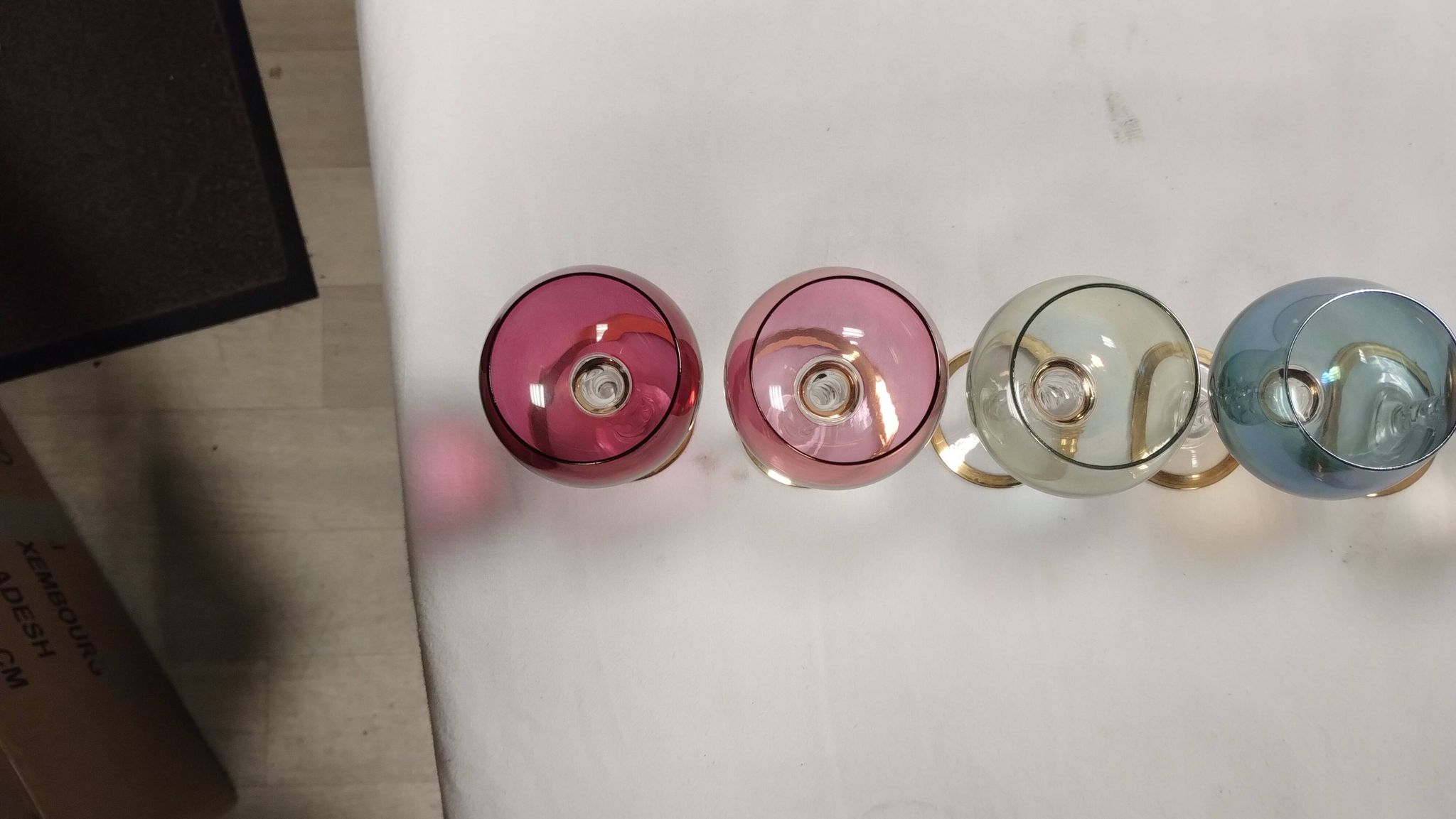 Set of 6 colored crystal stemmed glasses with gold twisted foot.