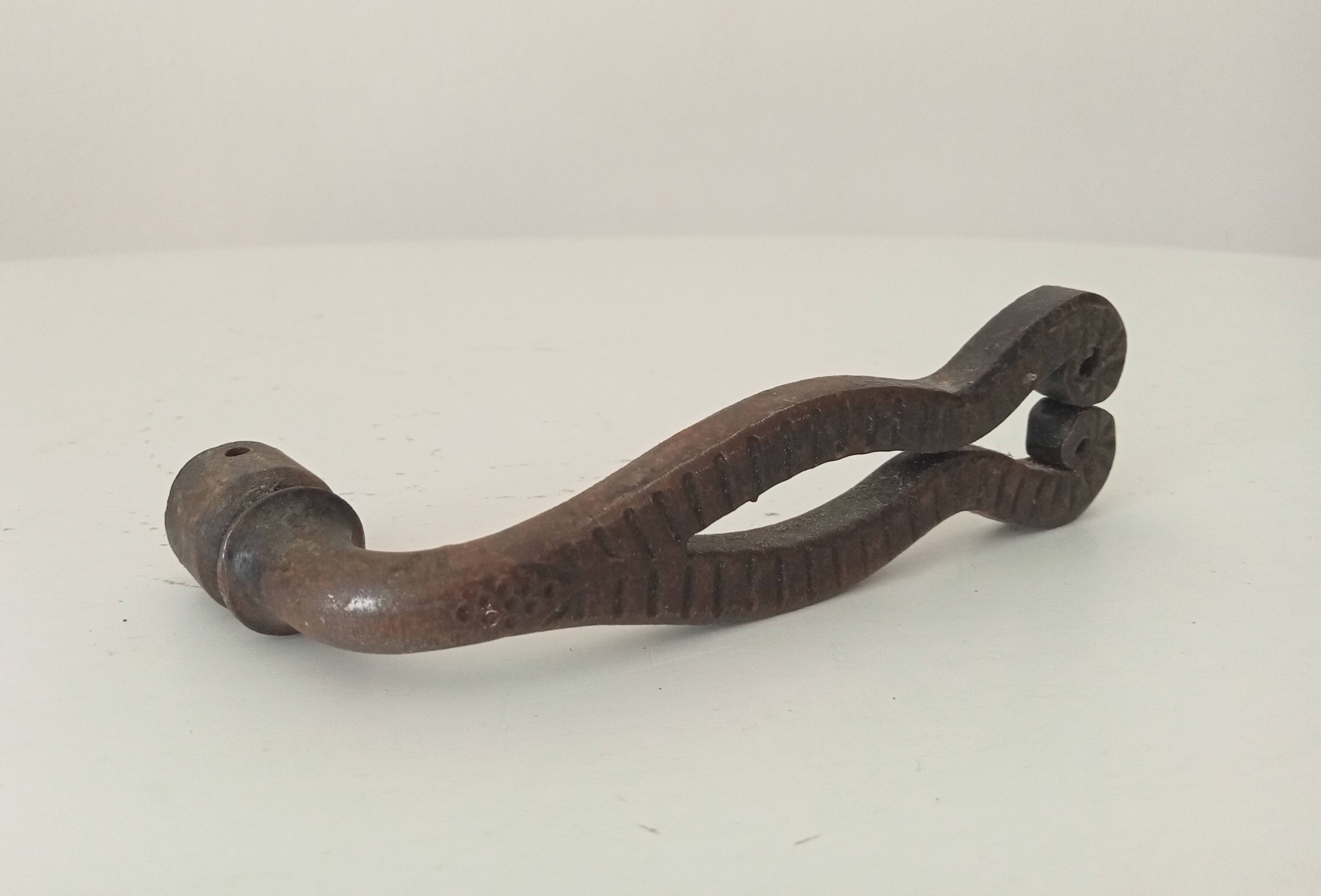 Antique wrought iron door handle with chiselled design.