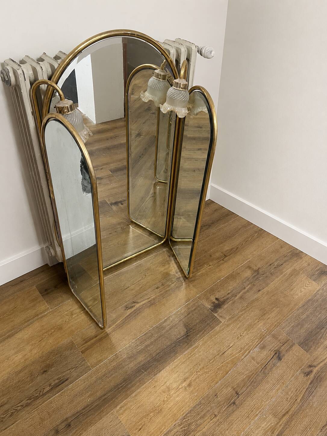 Vintage triptych mirror in brass with wall lights.