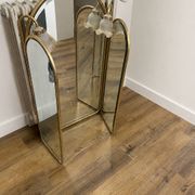 Vintage triptych mirror in brass with wall lights.