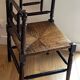Corner chair made of turned wood with a straw seat.