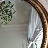 Old oval mirror in gilded wood