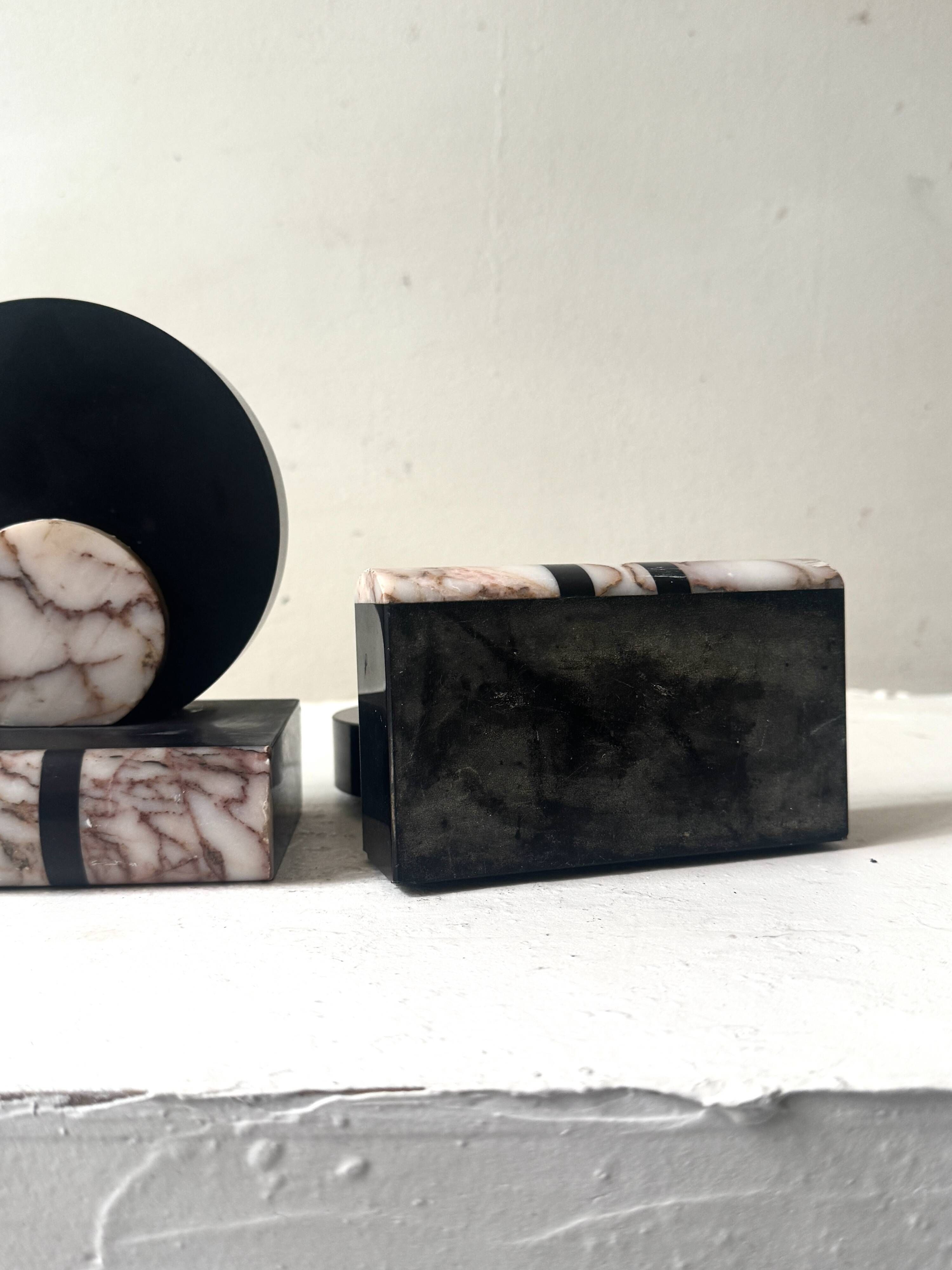 Art Deco bookends with a circular design in black and pink marble.