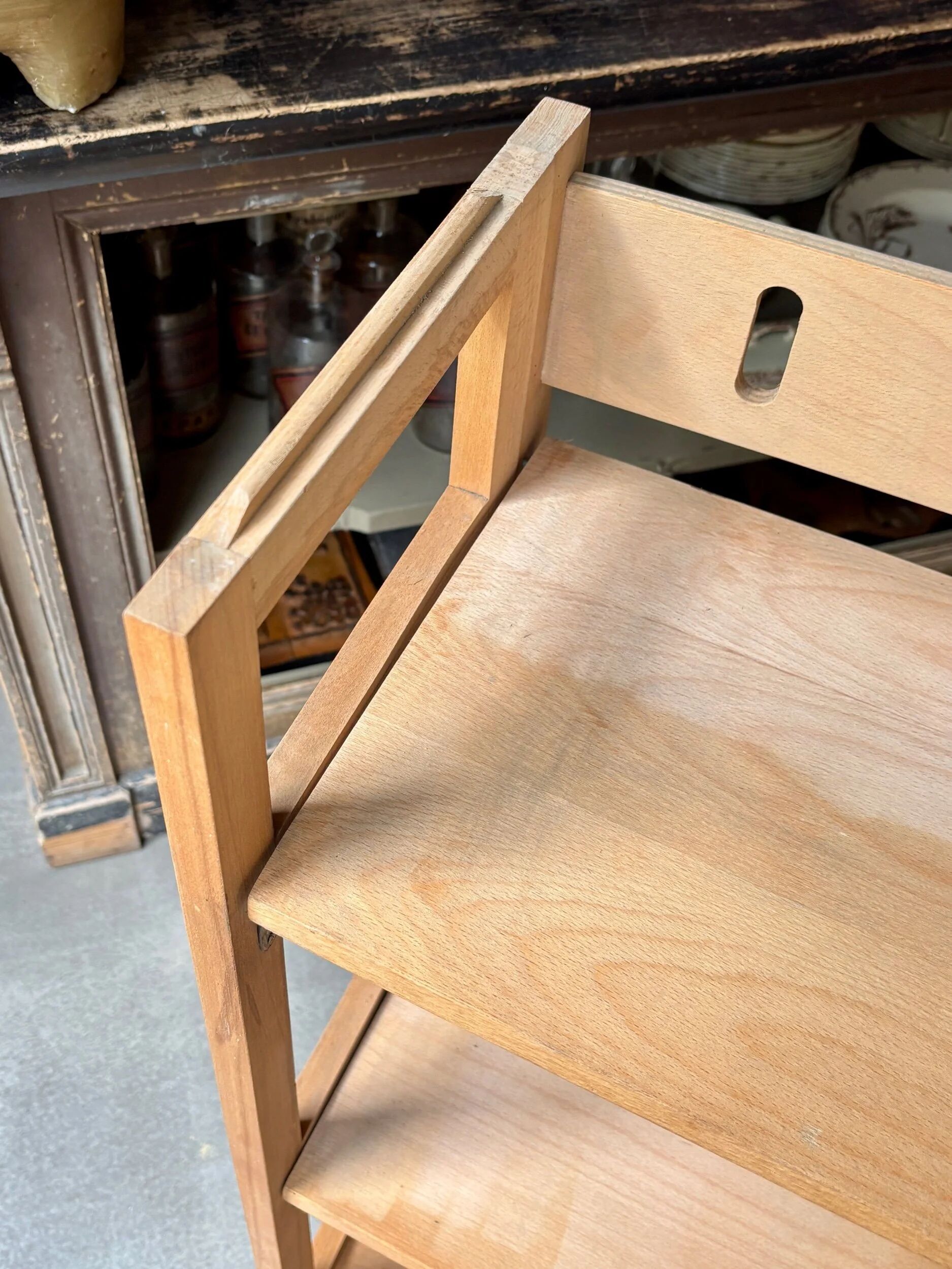 Folding bookshelf in light wood.