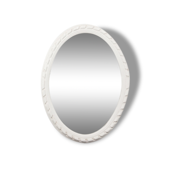 Miroir des années 1950 constitué d'un cadre en bois peint et d'une glace ovale.