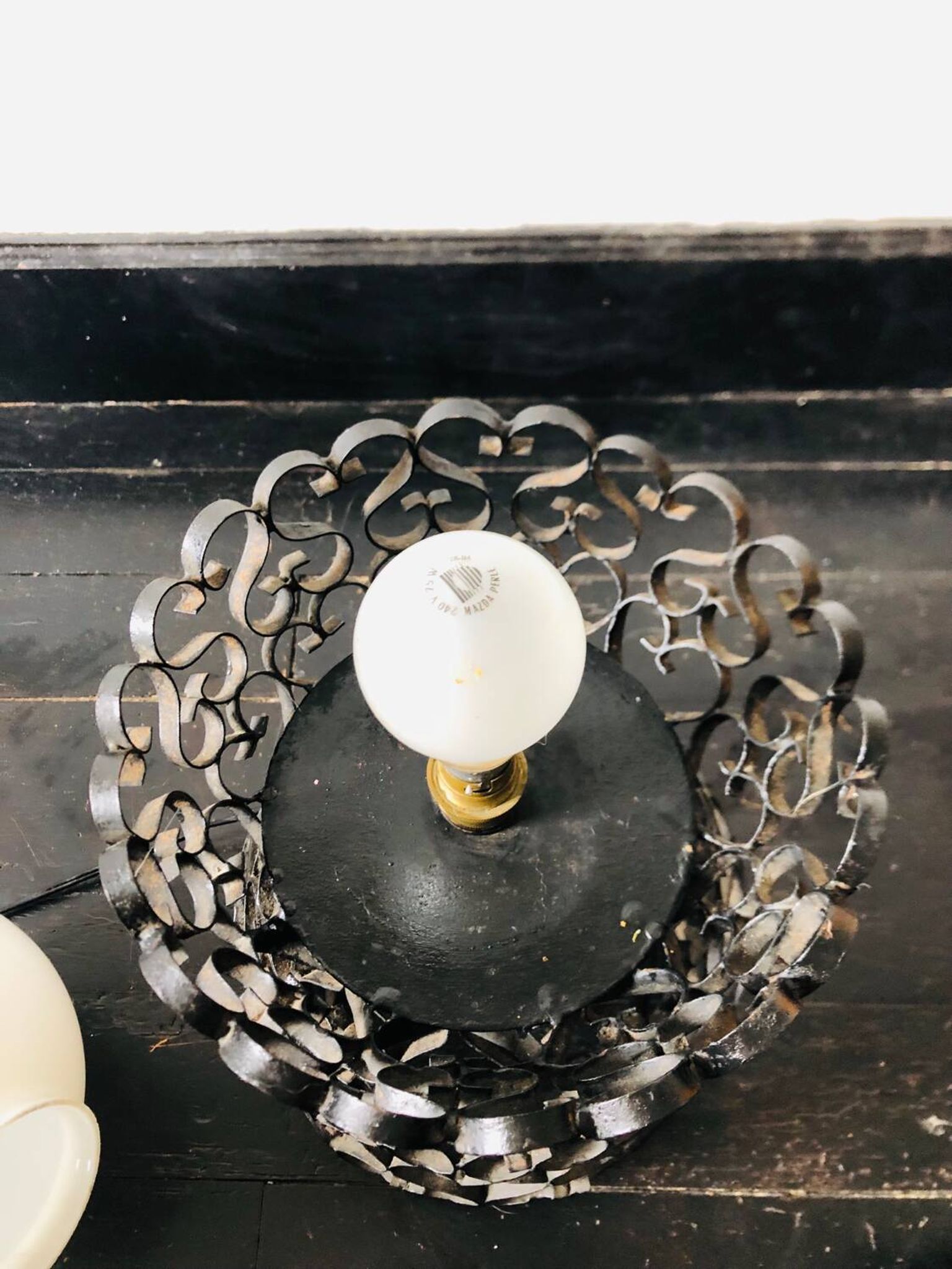 Black wrought iron lamp with a white glass globe.