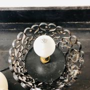 Black wrought iron lamp with a white glass globe.