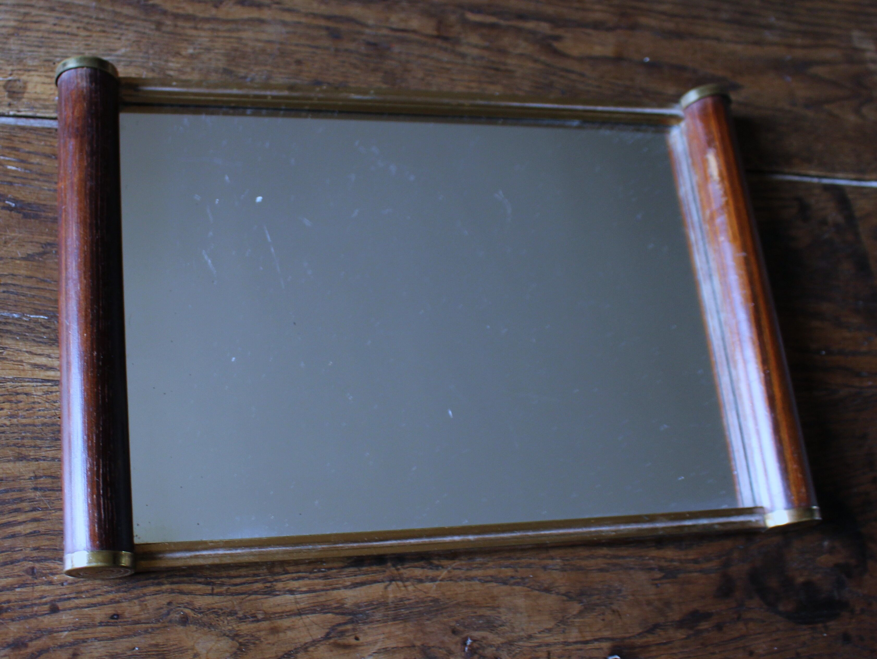 Rectangular mirror tray with wooden handles and gilding.