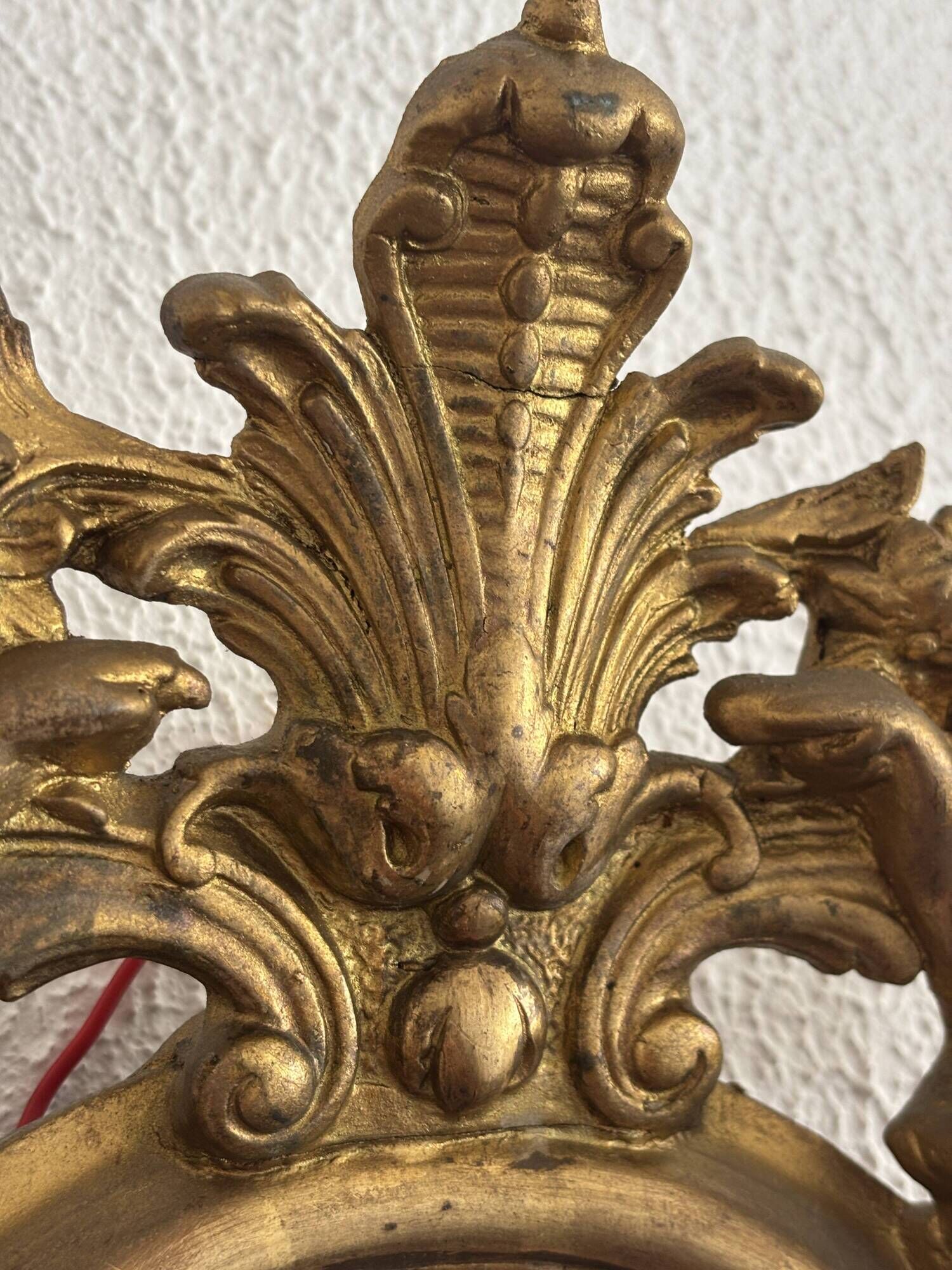 Antique rococo mirror with putti, gilded carved wood and stucco frame, 19th century.