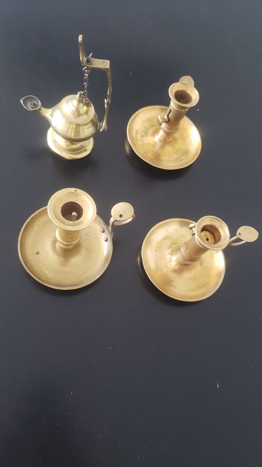 Many candlesticks and a small oil lamp.