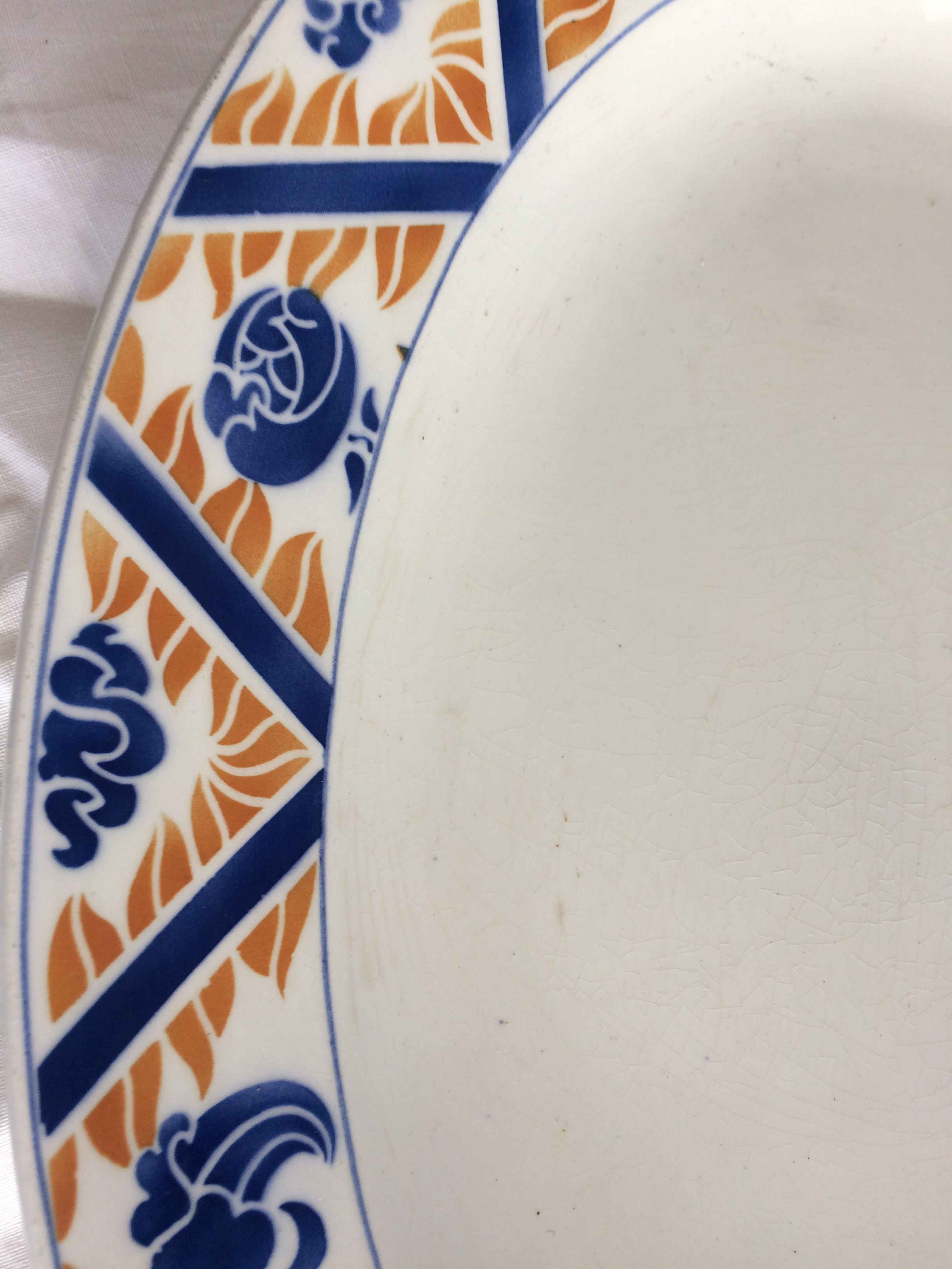Flat oval Art deco white background and blue, yellow frieze. Earthenware.