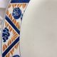 Flat oval Art deco white background and blue, yellow frieze. Earthenware.