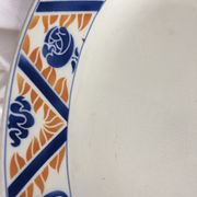 Flat oval Art deco white background and blue, yellow frieze. Earthenware.