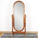 Large psychic mirror on legs with pivoting oval frame.