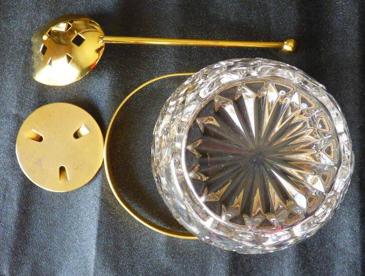 Glass and gold metal ice bucket with its gold metal spoon.