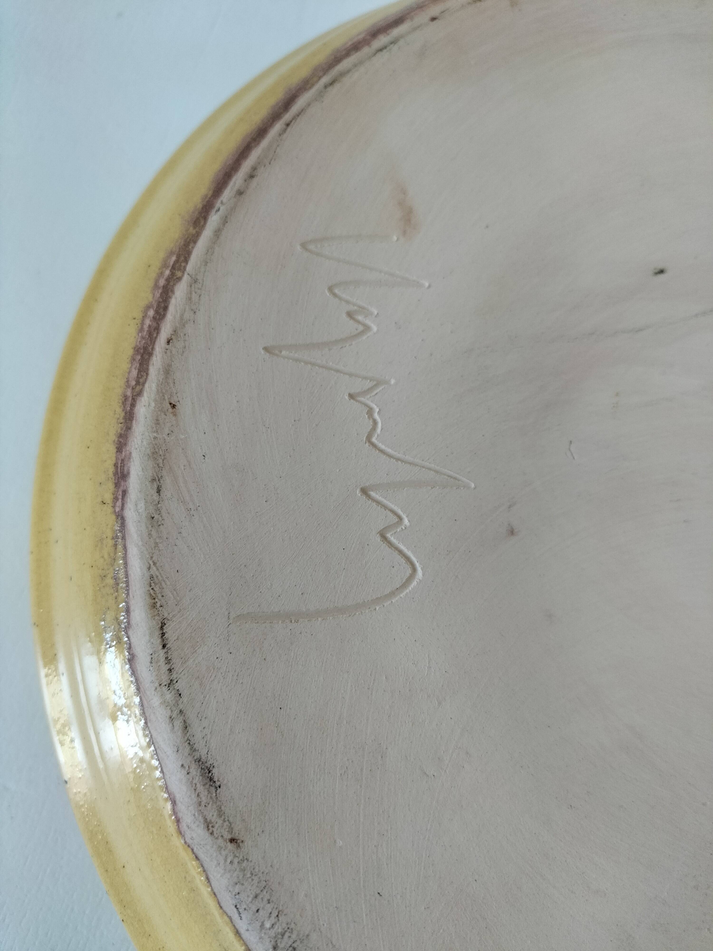 Blue floral glazed stoneware plate with a yellow rim.