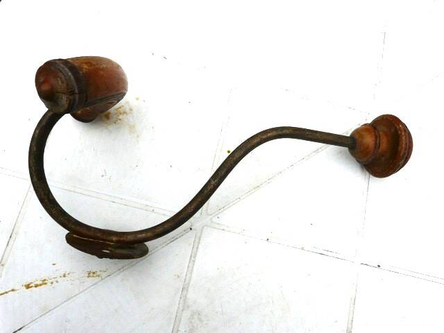 Wall-mounted coat rack with double hooks in metal and wood.