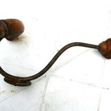 Wall-mounted coat rack with double hooks in metal and wood.