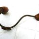 Wall-mounted coat rack with double hooks in metal and wood.