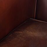 Comfortable, rugged cognac-colored sheepskin club armchair with a characteristic seat cushion