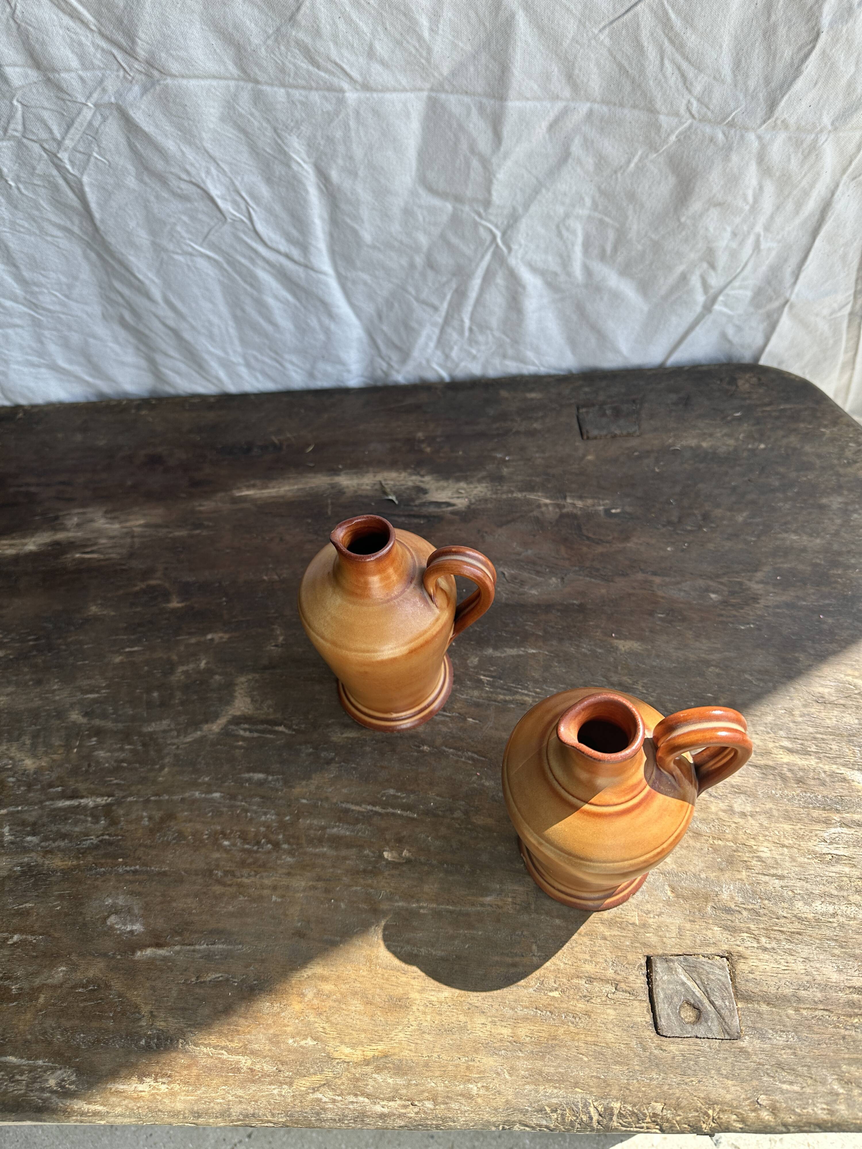 Pair of mini orange stoneware pitchers