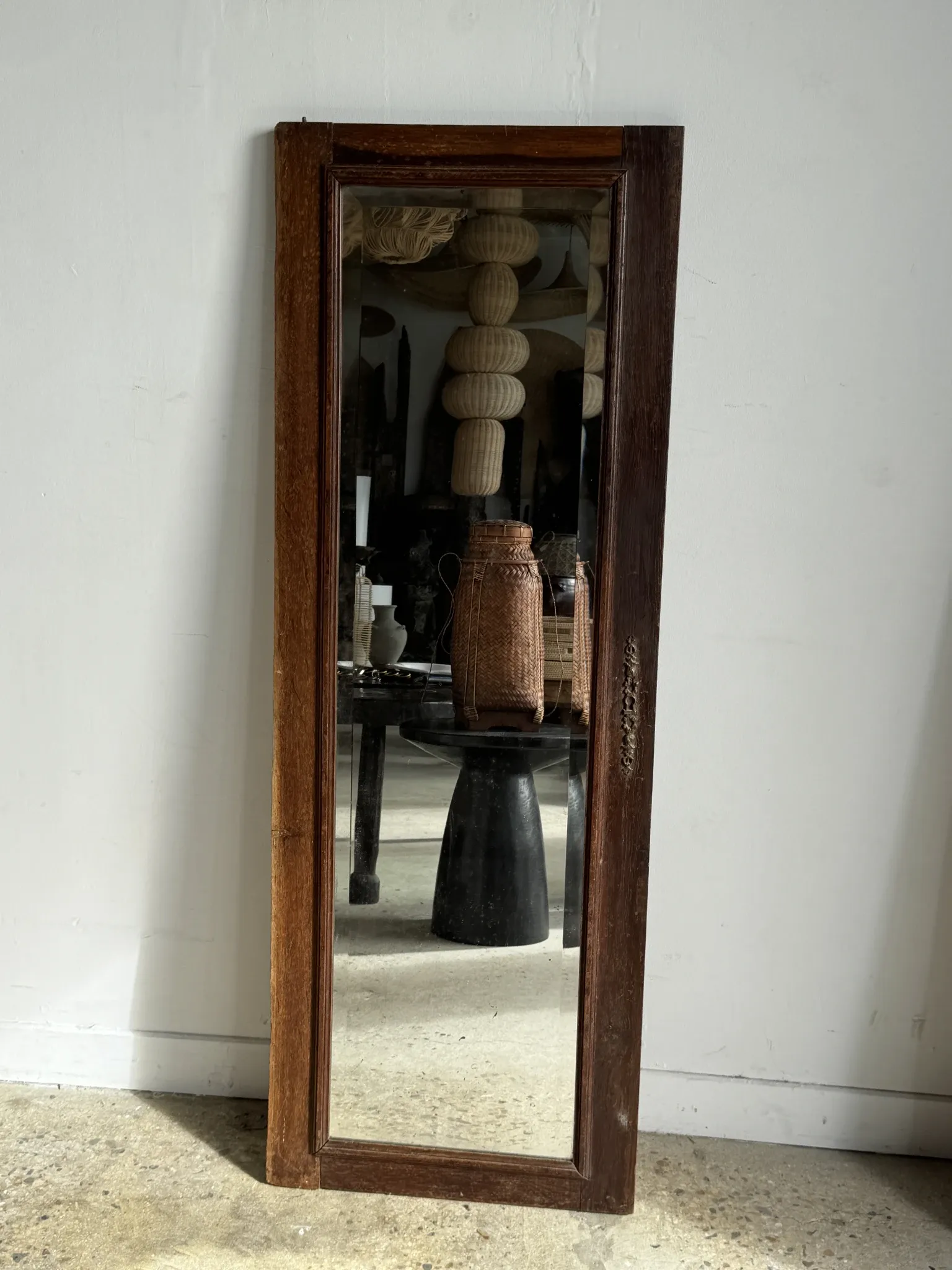 Antique mirror door (left) of a brown oak wardrobe with bevelled glass.