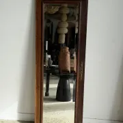 Antique mirror door (left) of a brown oak wardrobe with bevelled glass.