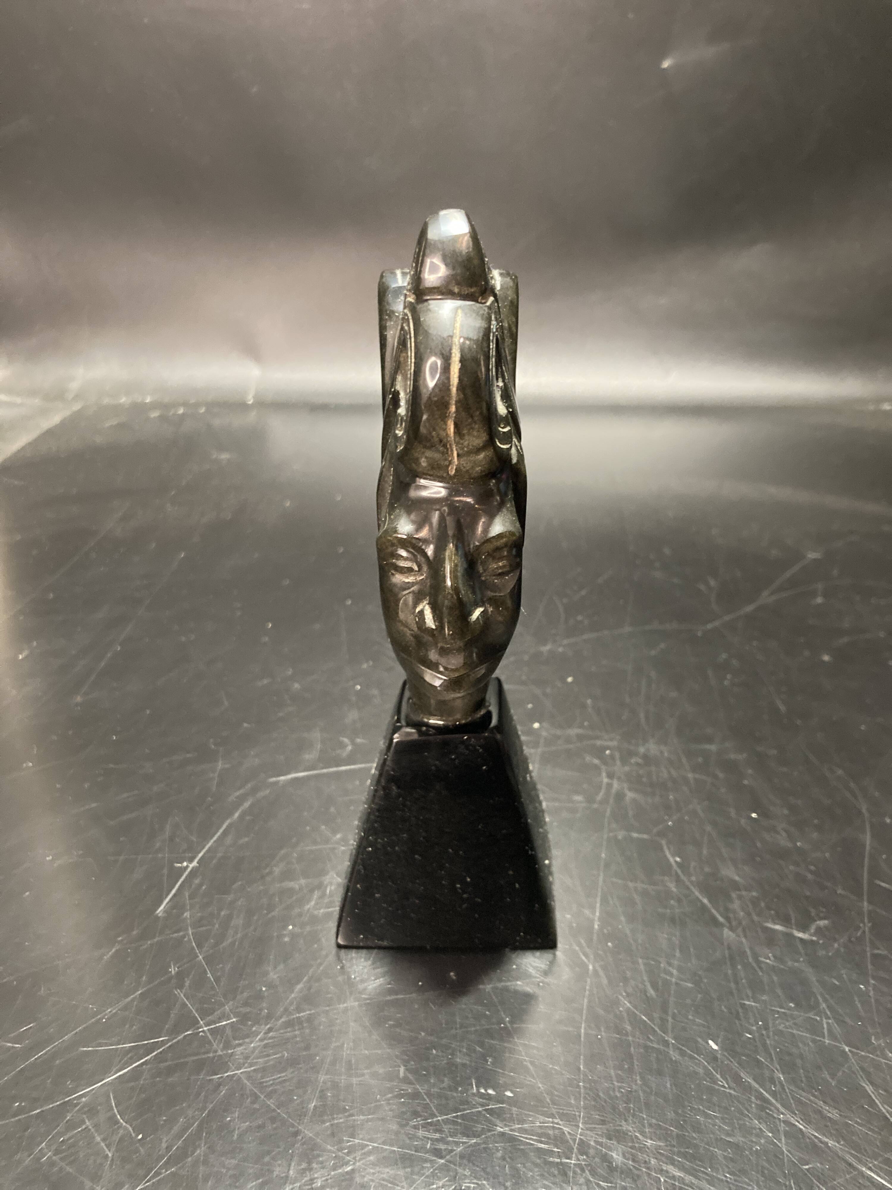 Ceramic sculpture representing a woman's face placed on a black base