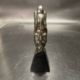 Ceramic sculpture representing a woman's face placed on a black base