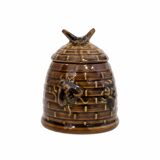 Honey pot in the shape of a hive decorated with bees.