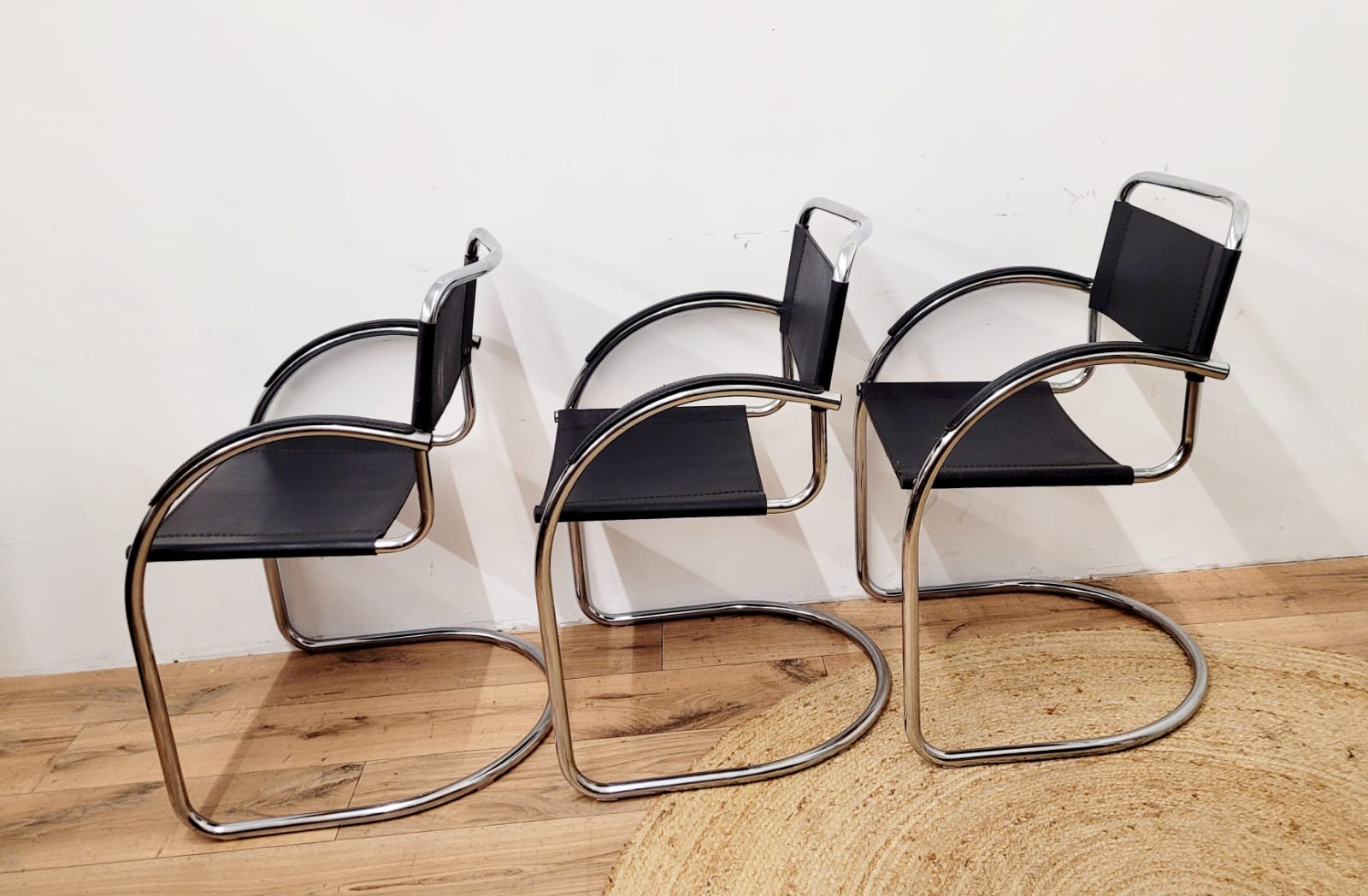 Three armchairs in black leather and steel tube