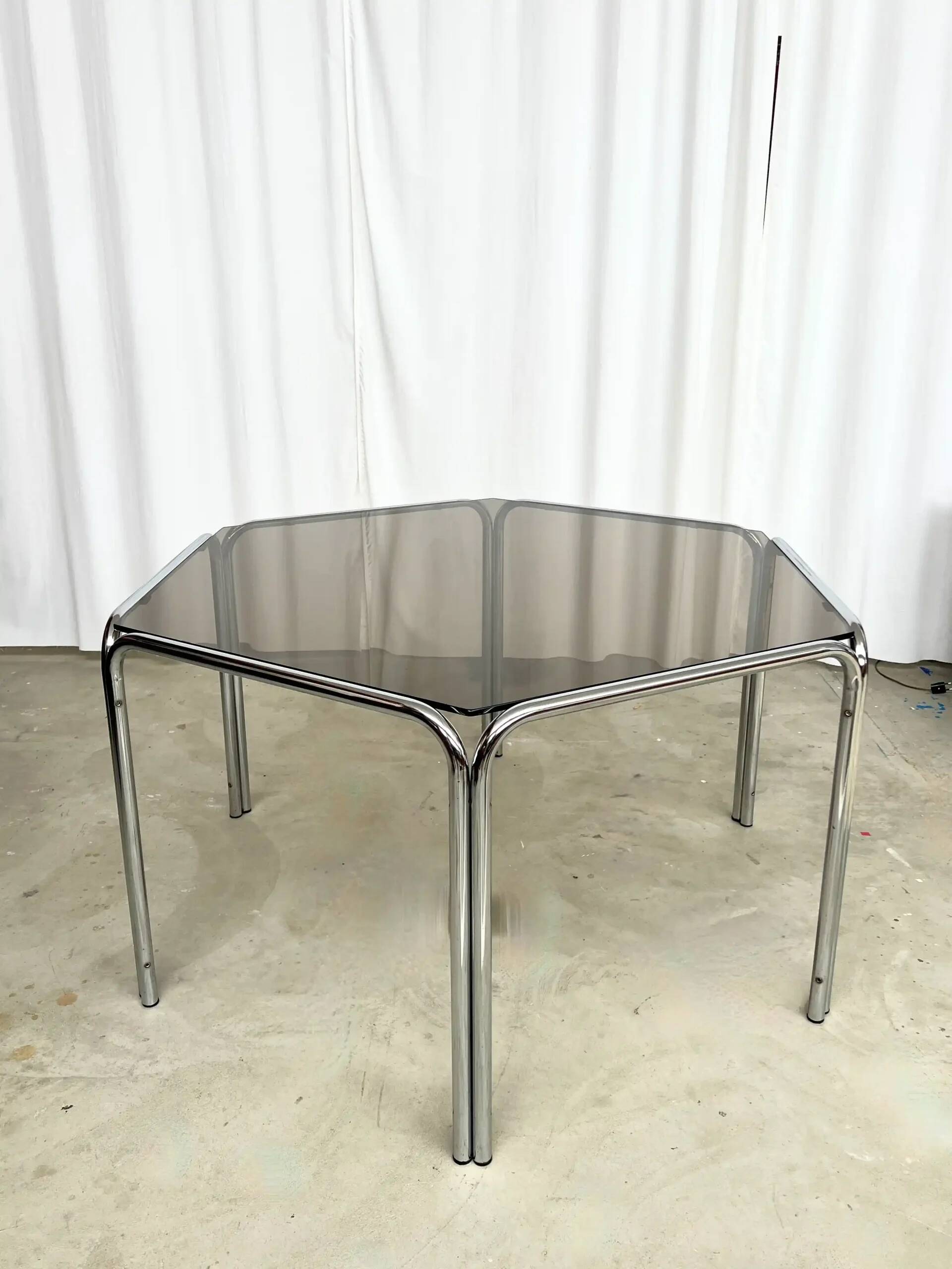 Vintage hexagonal table with smoked glass top and chrome metal structure.