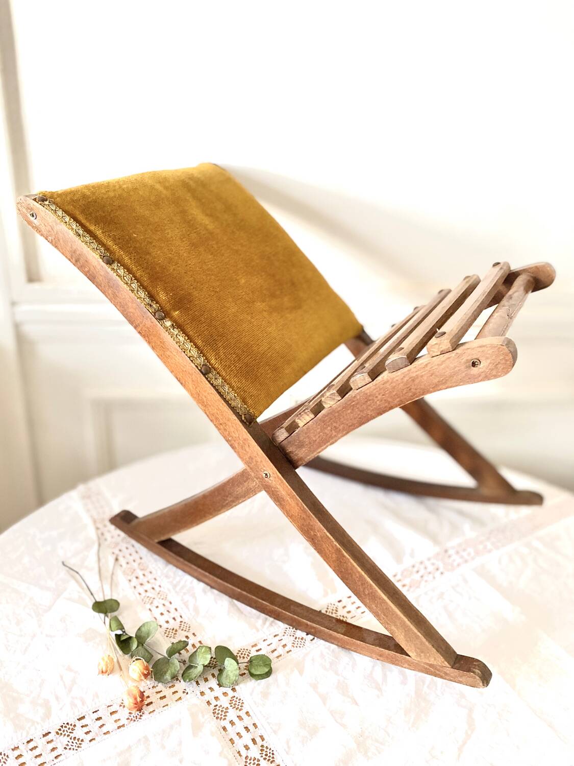 Old wooden rocking footrest with velvet fabric