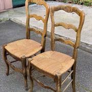2 solid oak carved and rush-seated chairs in the Louis XV style from the 19th century.