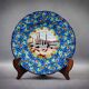 Longwy plate with polychrome enamels, decorated with the "City of Iron" motif.